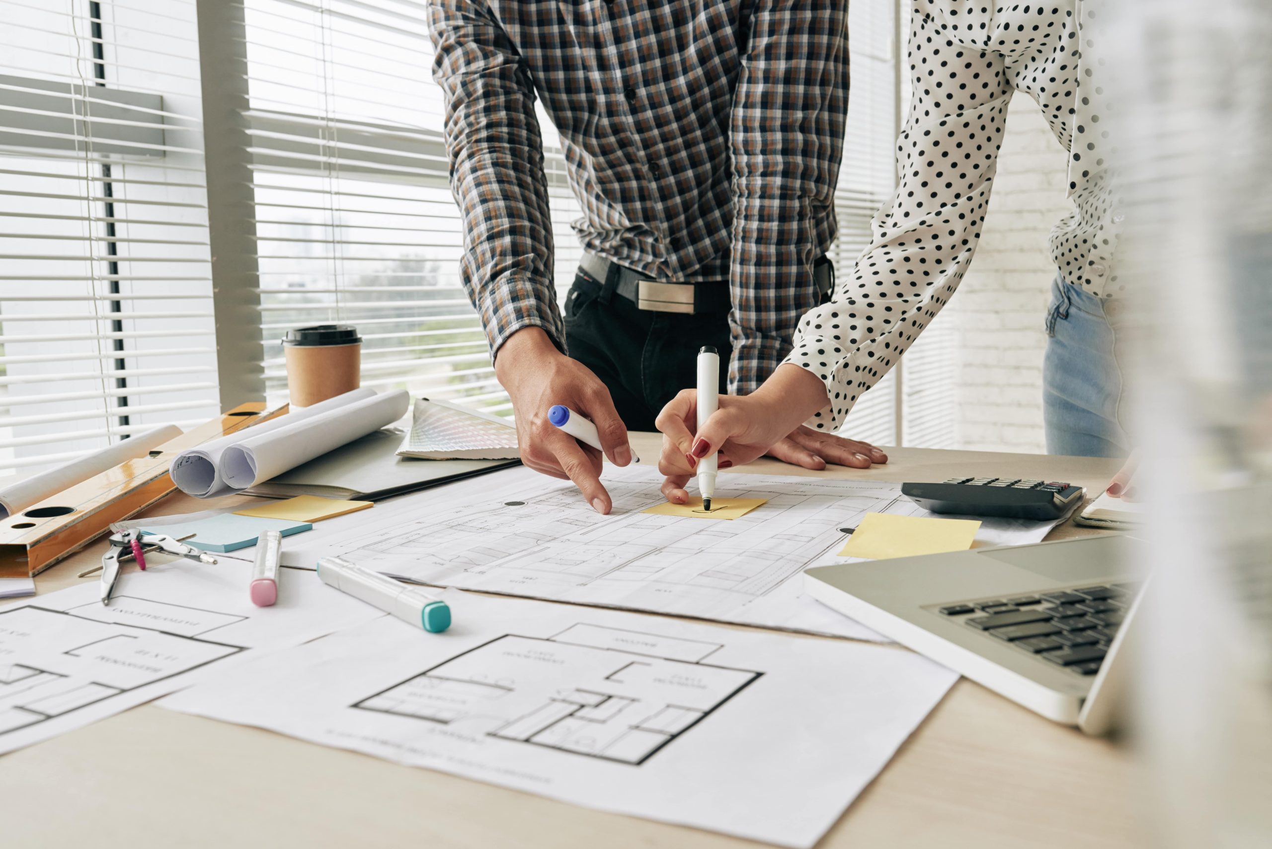 Deux architectes qui travaillent sur un plan de toiture commerciale au Québec